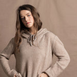 a woman wears a pure, 100% cashmere sweater in beige with jeans