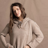 a woman wears a pure, 100% cashmere sweater in beige with jeans