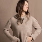 a woman wears a luxury cashmere hoodie in beige with jeans