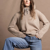 a woman wears a pure, 100% cashmere jumper in beige with jeans