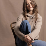a woman wears a pure, 100% cashmere sweater in beige with jeans