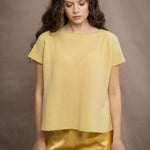 a woman wears a pure 100% cashmere tee sweater in butter yellow over silk trousers in butter yellow