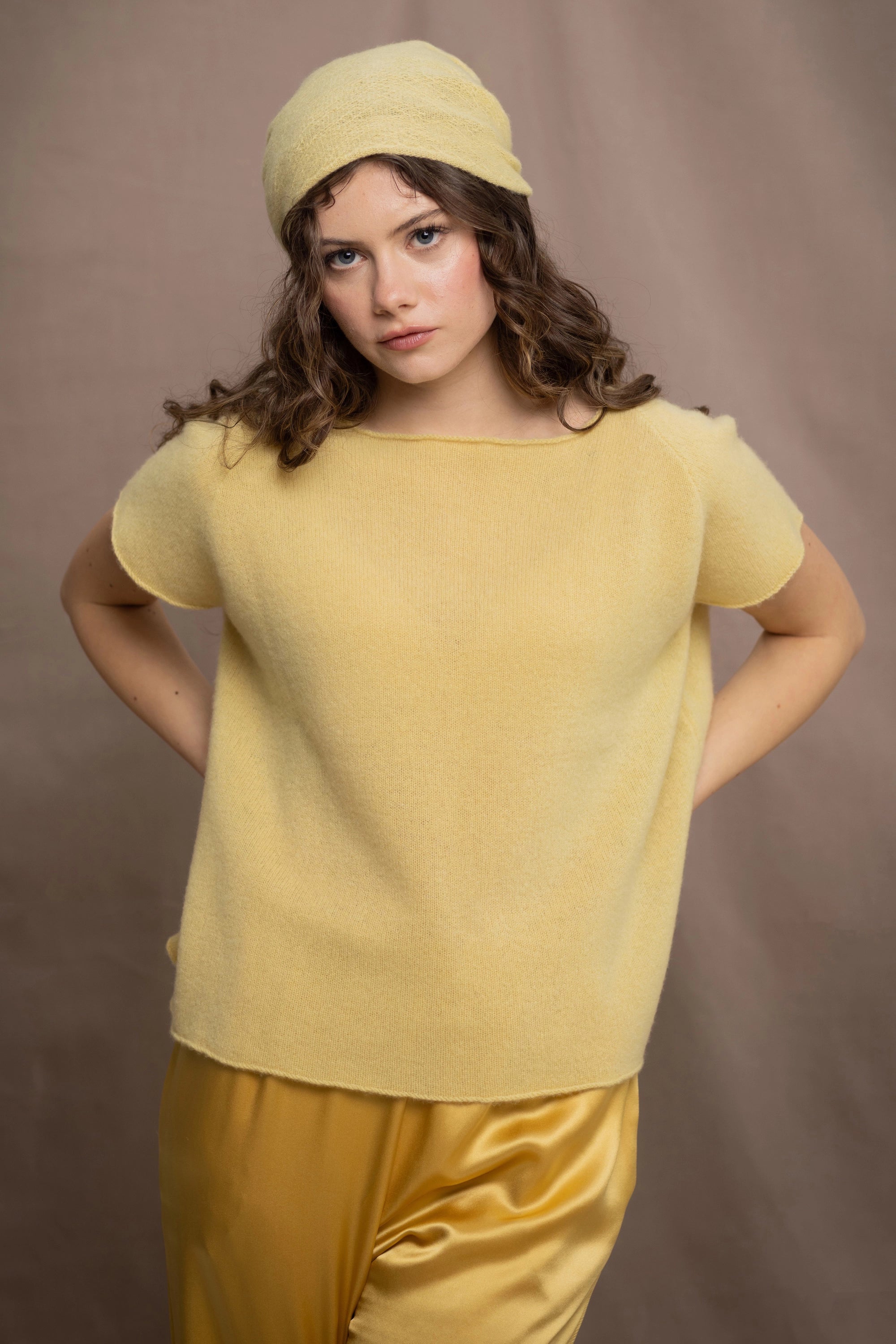 a woman wears a pure 100% cashmere tee sweater in butter yellow with a matching cashmere beanie hat in yellow