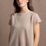 A woman wears a 100% cashmere tshirt in beige with pure silk shorts in black