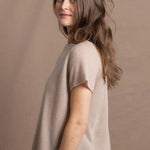 A woman wears a 100% cashmere tee in beige