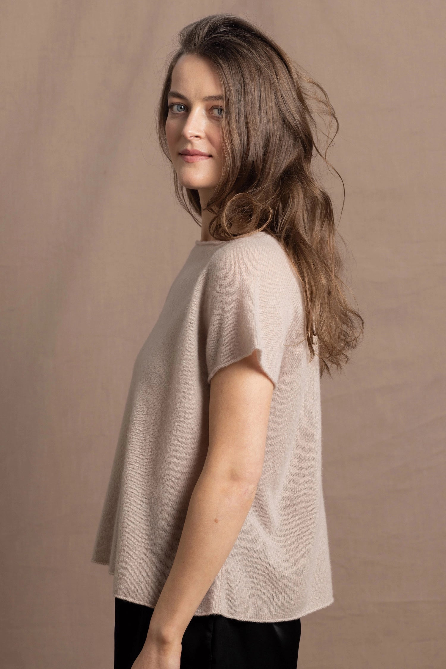 A woman wears a 100% cashmere tee in beige