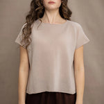 a woman wears a beige cashmere tee with silk trousers in chocolate brown