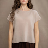 a woman wears a beige cashmere tee with silk trousers in chocolate brown
