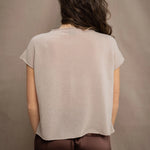 a woman wears a beige cashmere tee with silk trousers in chocolate brown