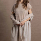 A woman wears a large cashmere shawl in beige over a matching cashmere tee