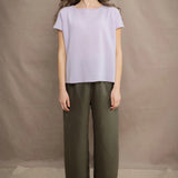 a woman wears a 100% pure cashmere tee sweater in light purple by Irish brand Madigan Cashmere with silk trousers in green