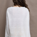 a woman wears a pure 100% cashmere sweater jumper in white over yellow silk trousers
