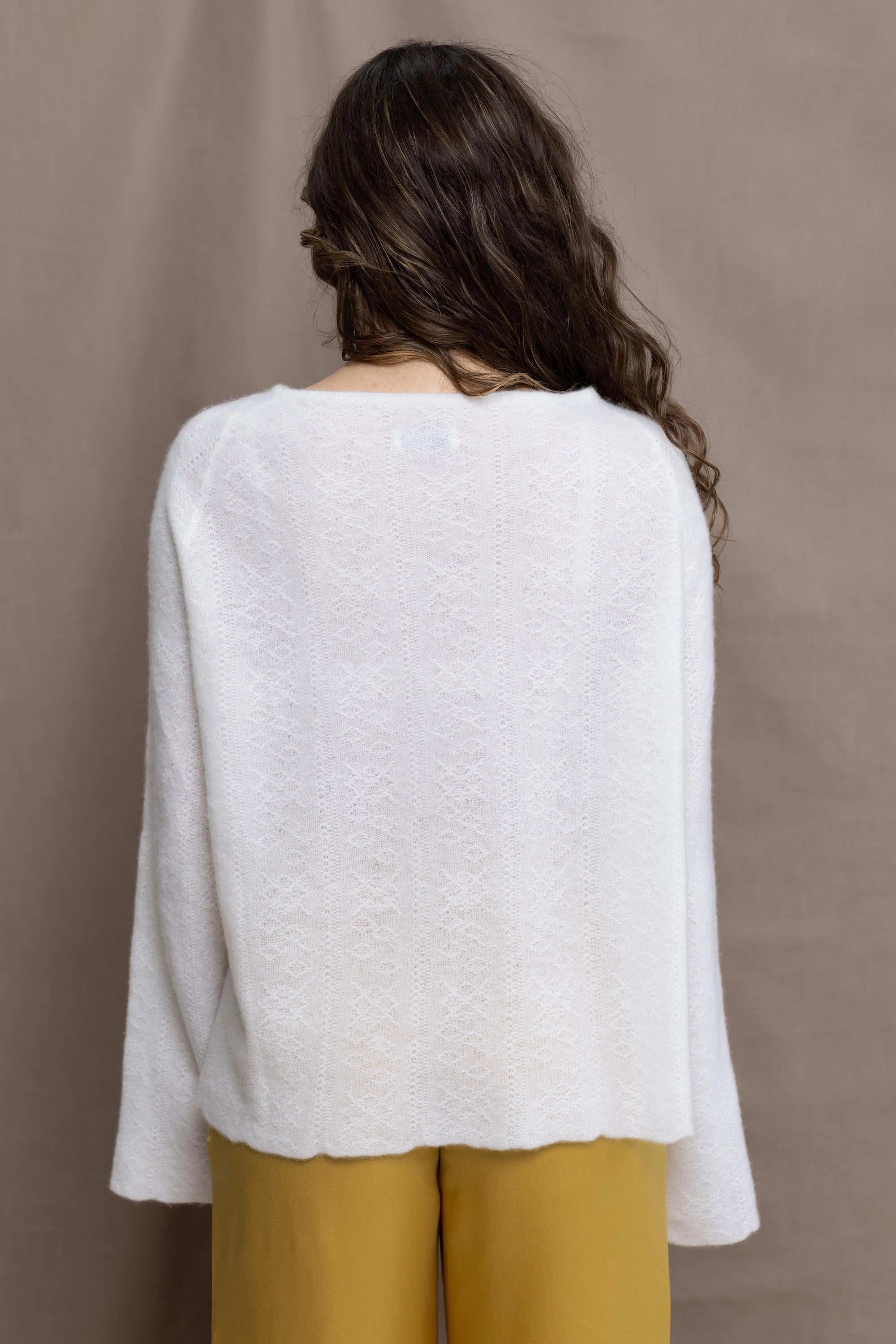 a woman wears a pure 100% cashmere sweater jumper in white over yellow silk trousers