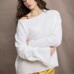 a woman wears a pure 100% cashmere sweater jumper in white over yellow silk trousers