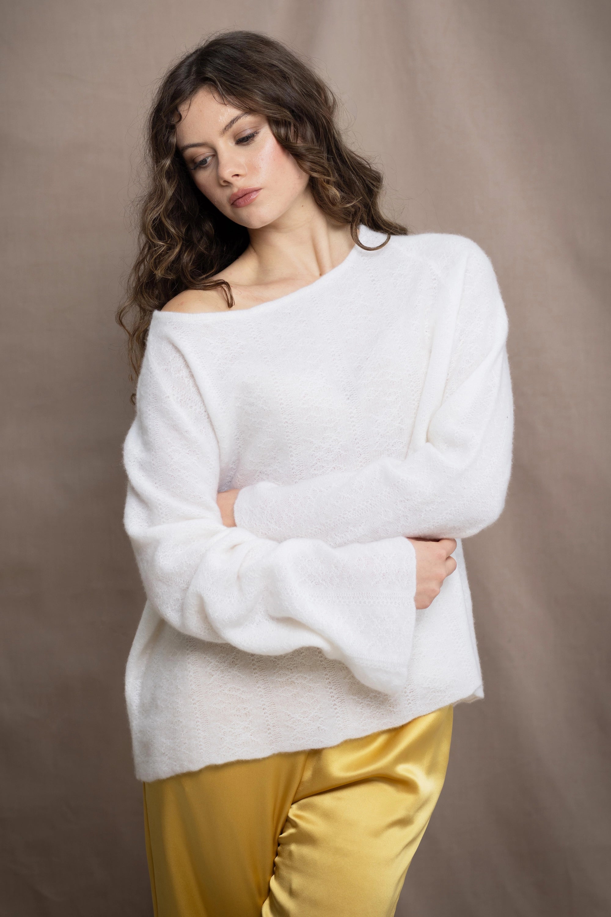 a woman wears a pure 100% cashmere sweater jumper in white over yellow silk trousers