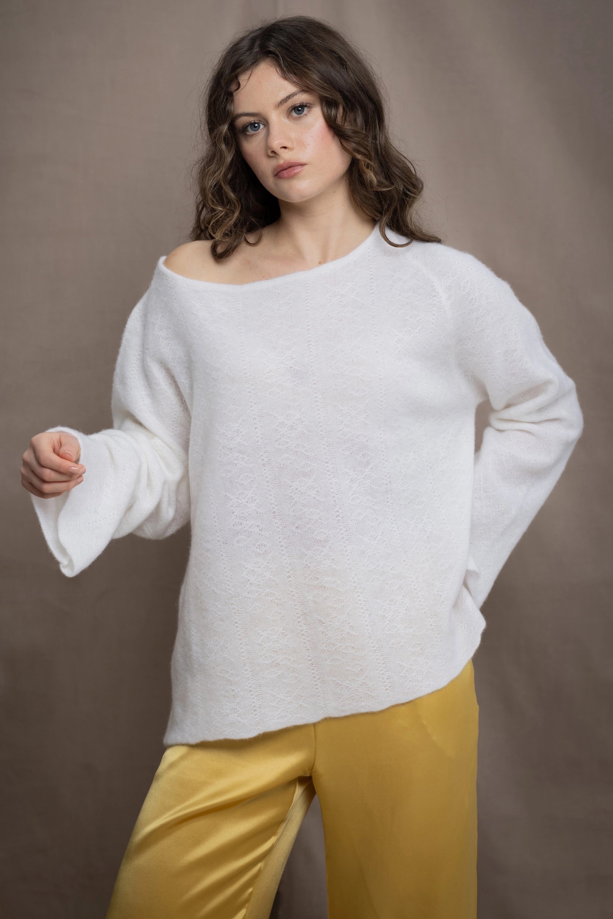 a woman wears a pure 100% cashmere sweater jumper in white over yellow silk trousers