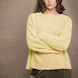 a woman wears a pale yellow cashmere pointelle sweater by Irish brand Madigan Cashmere