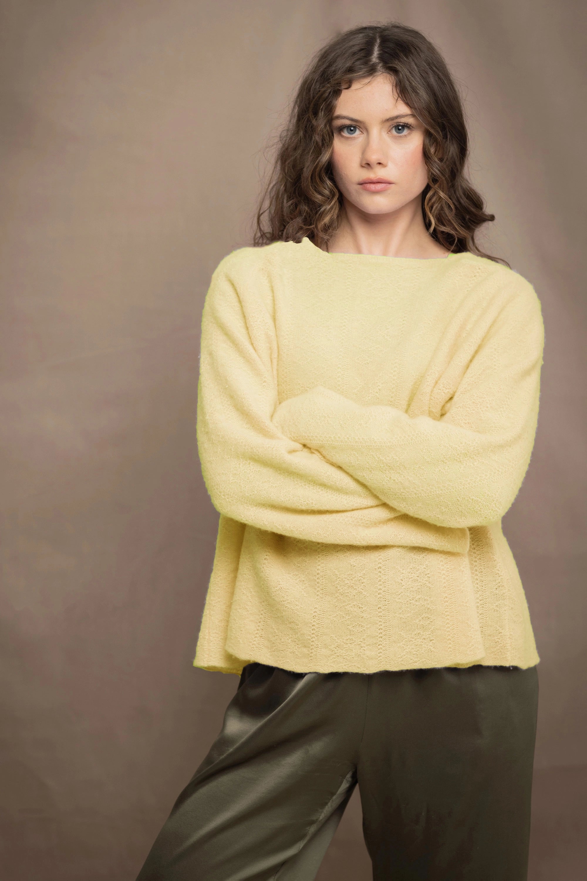 a woman wears a pale yellow cashmere pointelle sweater by Irish brand Madigan Cashmere