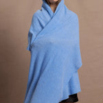 a woman wears a pure, 100% cashmere wrap in blue