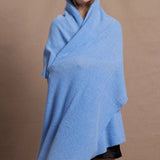 a woman wears a pure, 100% cashmere wrap in blue
