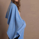 a woman wears a luxury cashmere shawl in blue