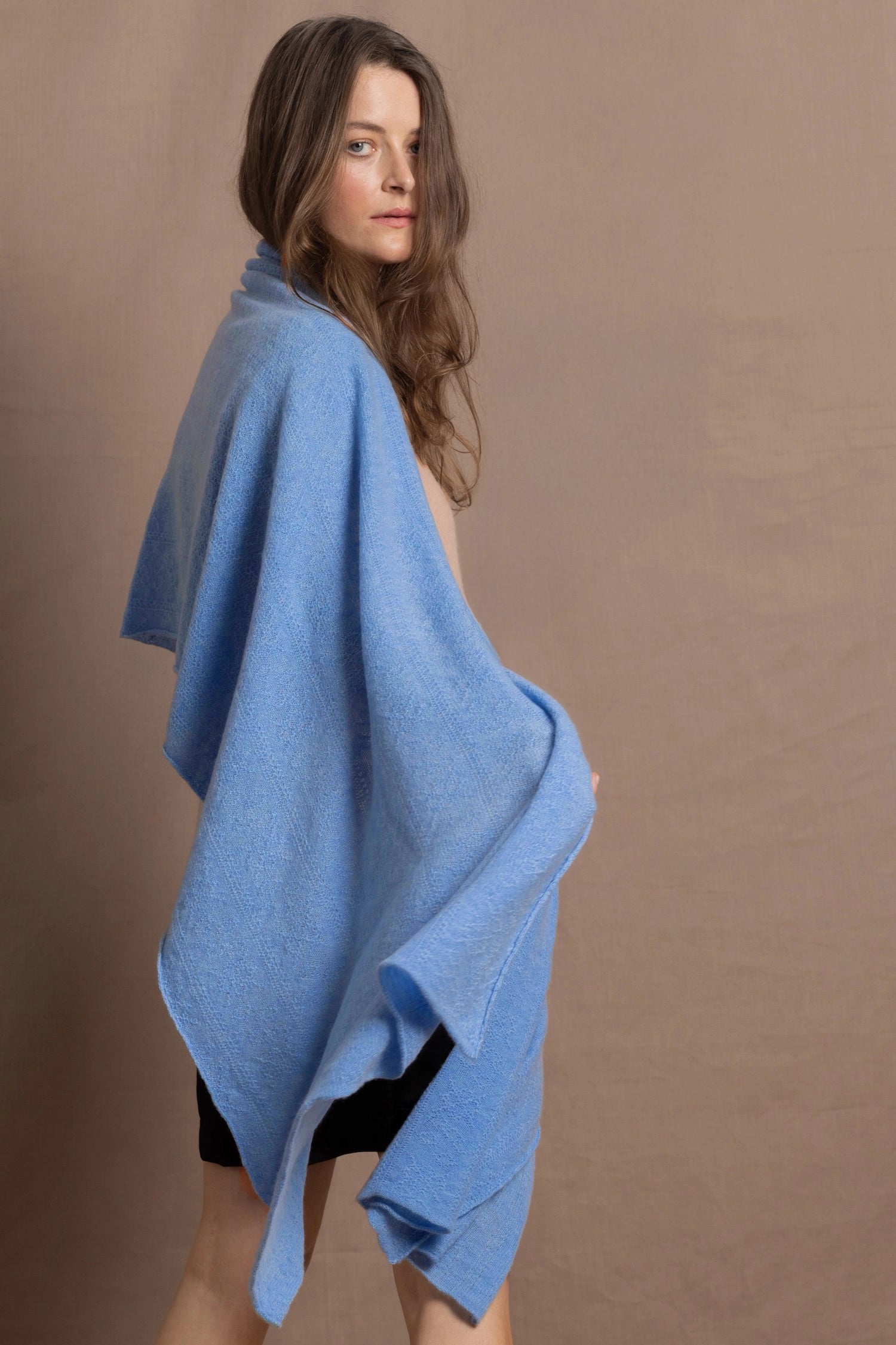 a woman wears a luxury cashmere shawl in blue