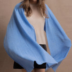 a woman wears a luxury cashmere wrap in blue