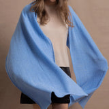 a woman wears a luxury cashmere wrap in blue