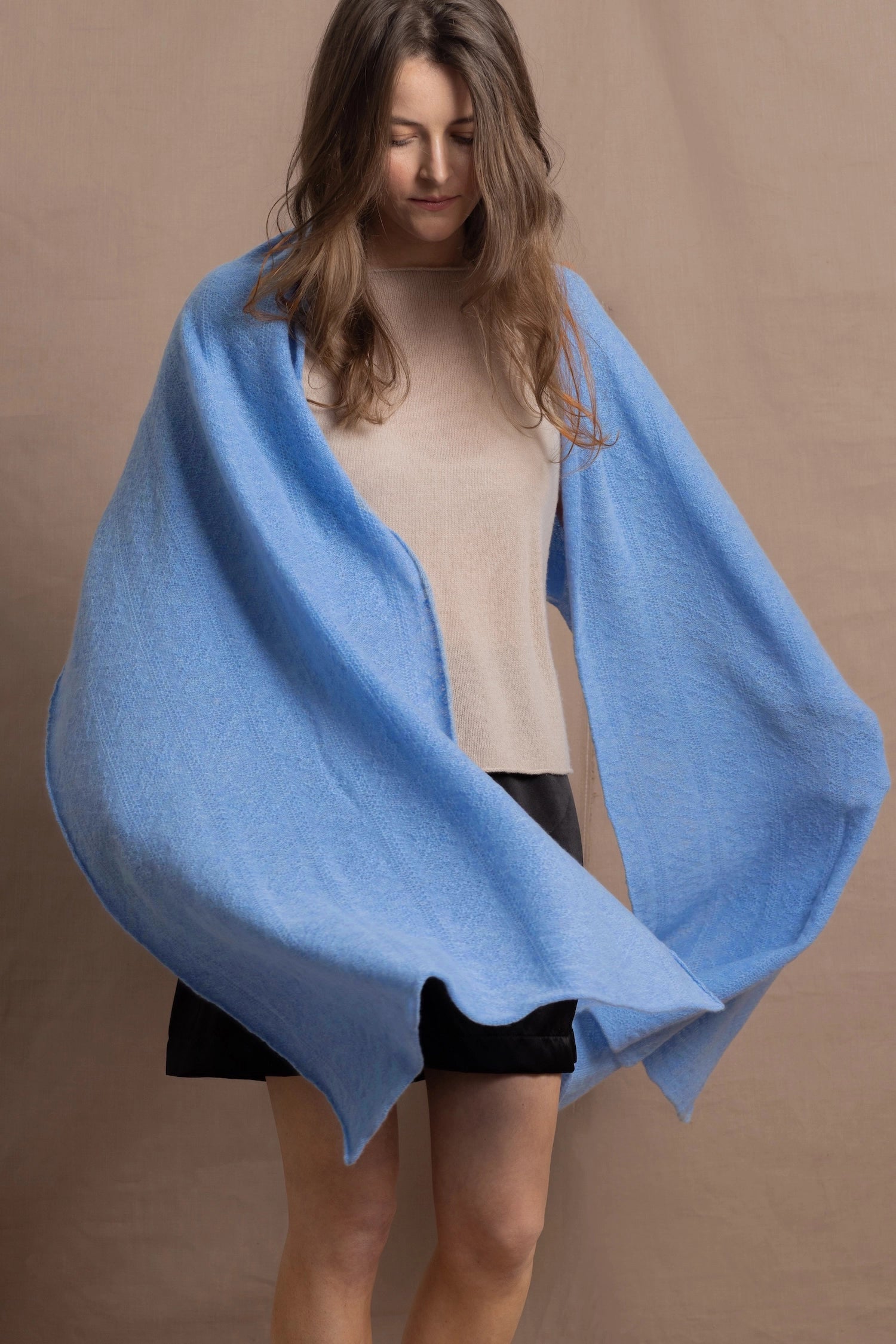a woman wears a luxury cashmere wrap in blue