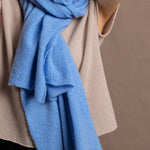 a woman wears a pure, 100% cashmere scarf in blue