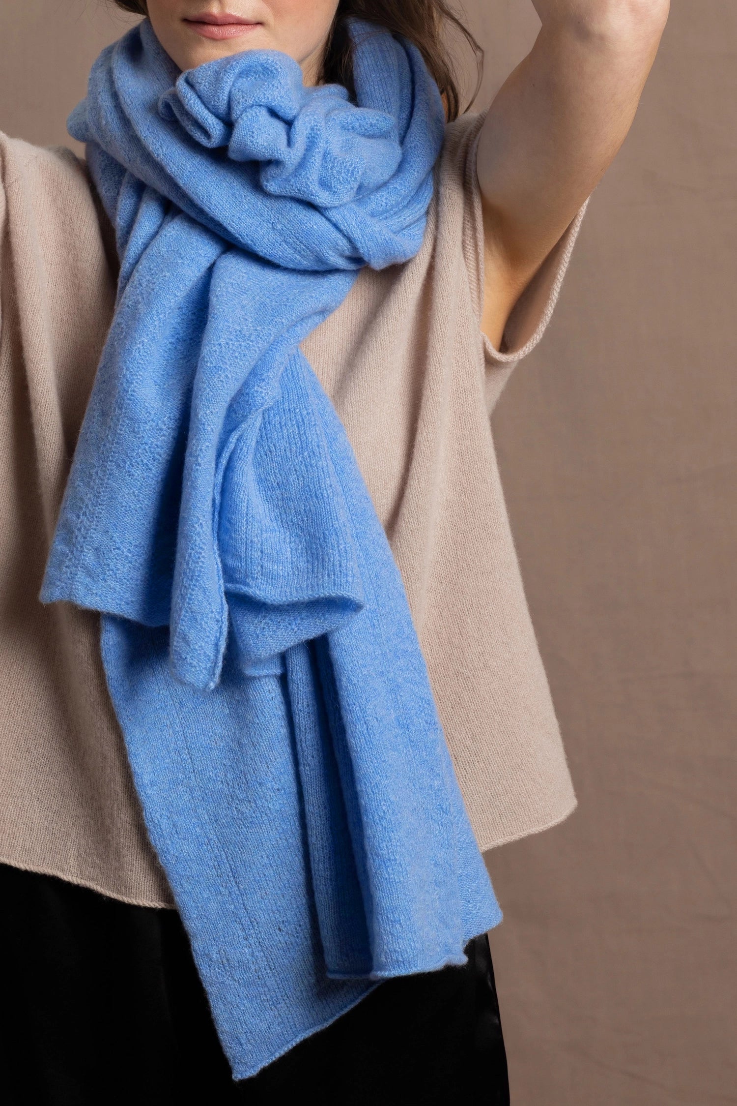 a woman wears a pure, 100% cashmere scarf in blue