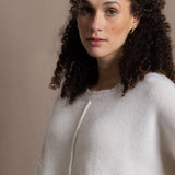 A woman wears an oversized 100% cashmere sweater in Ivory 