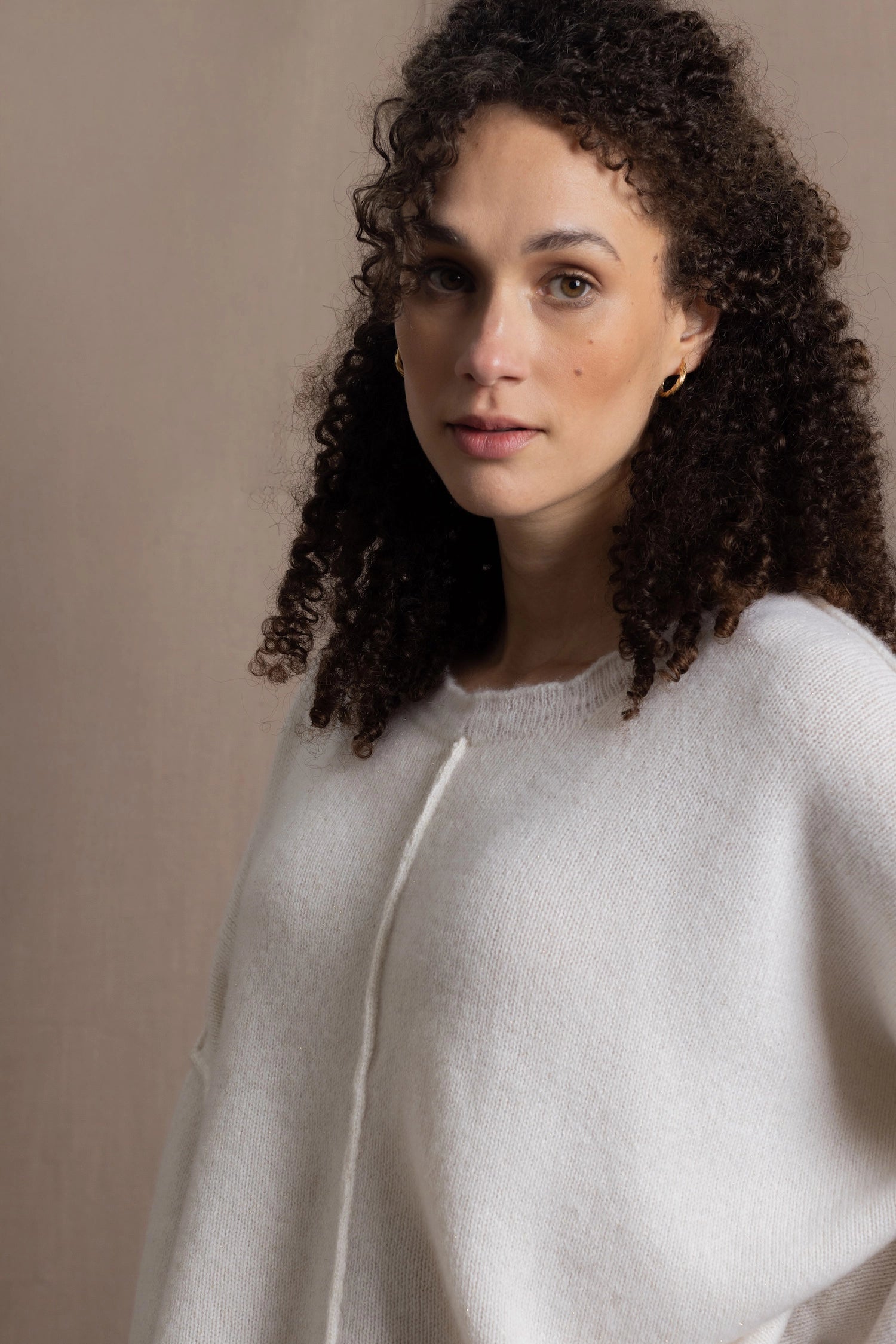 A woman wears an oversized 100% cashmere sweater in Ivory 
