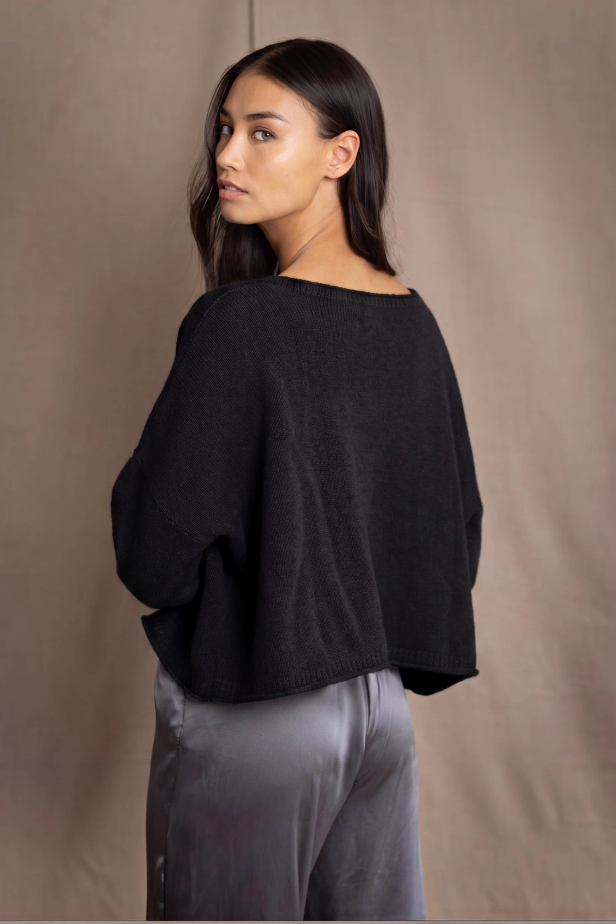 a woman wears a 100% Cashmere Cropped Oversized Sweater in Black by Irish brand Madigan Cashmere