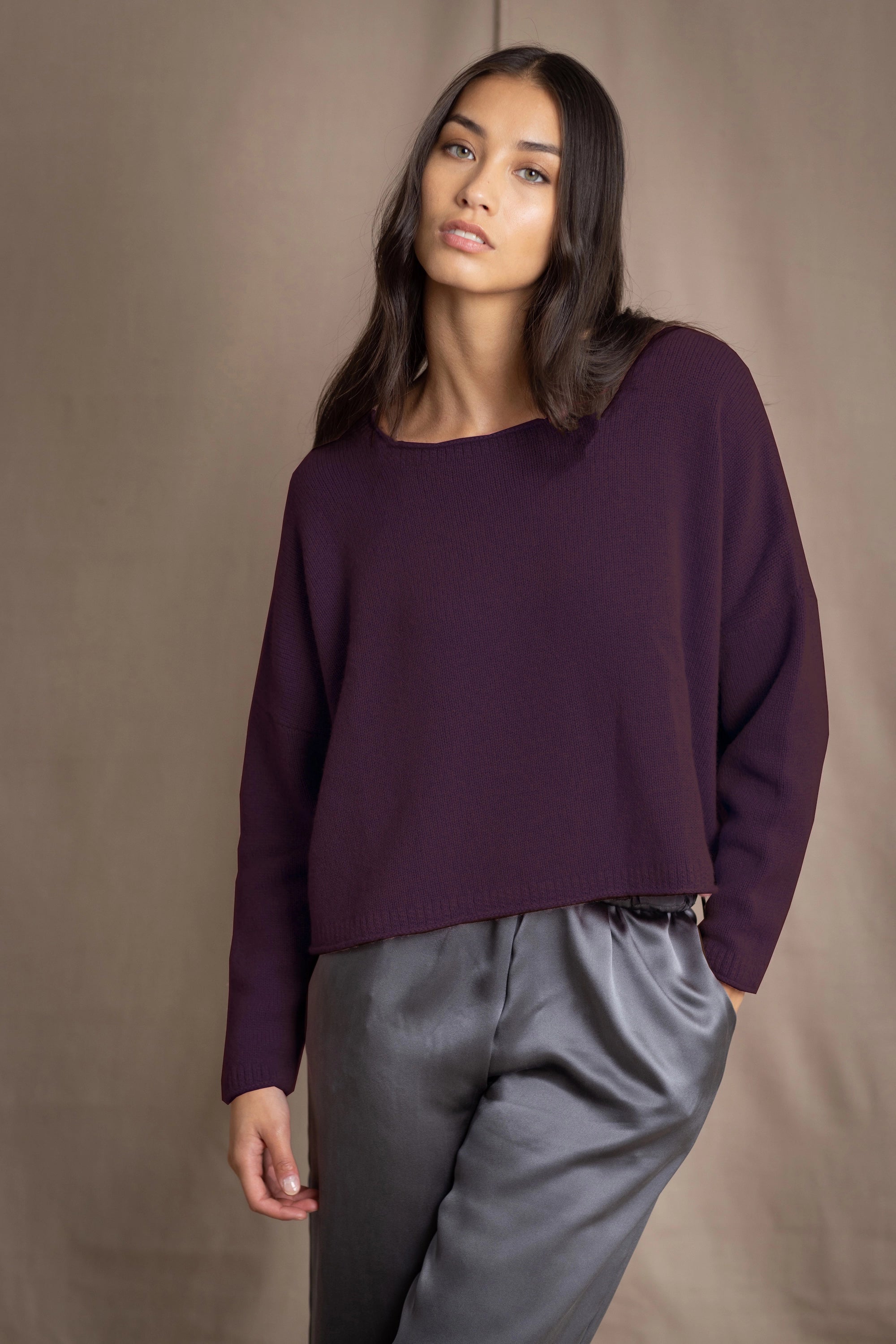 Woman wearing a purple cashmere sweater and gray silk pants