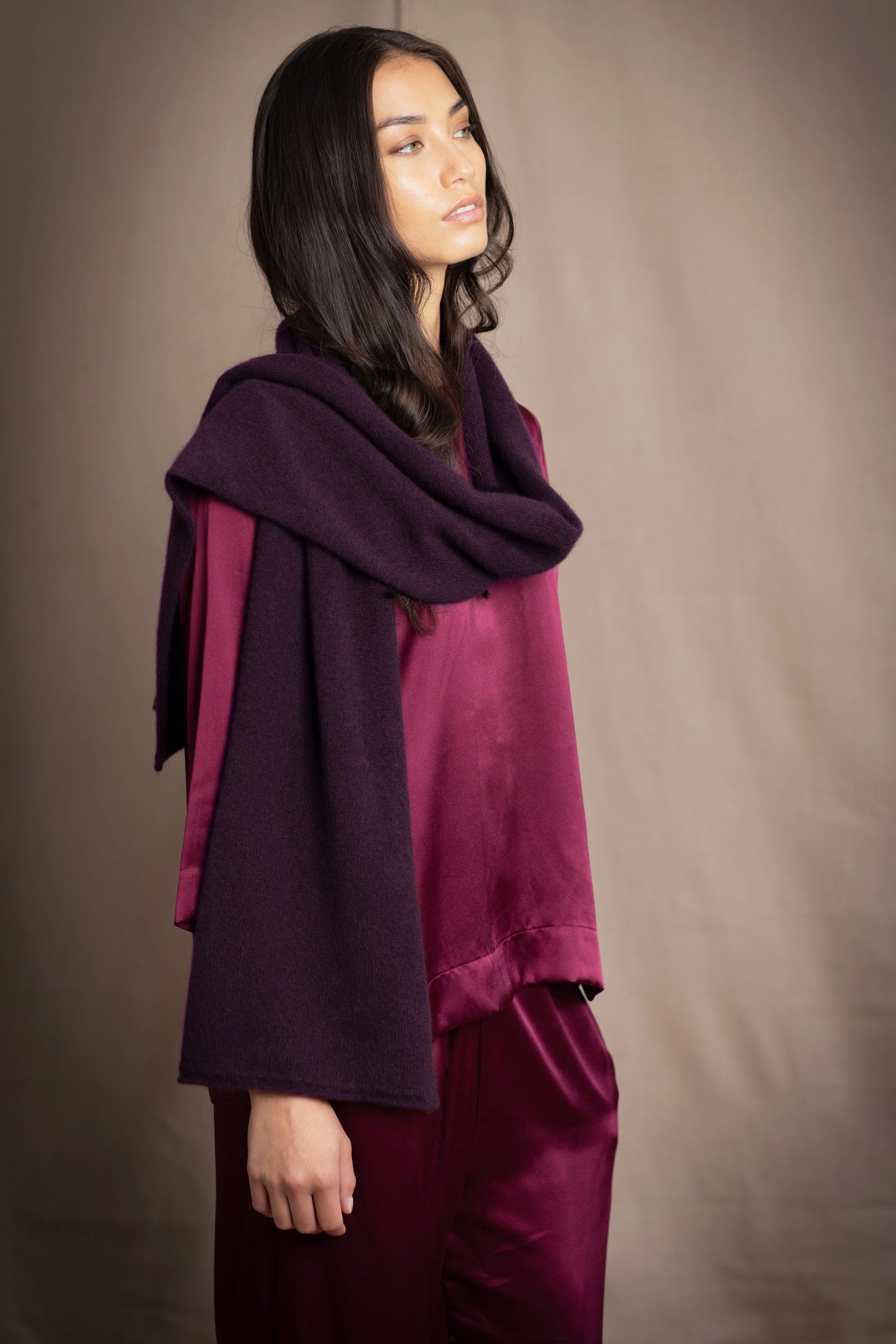 a woman wearing a cashmere scarf in dark purple over burgundy silk clothing