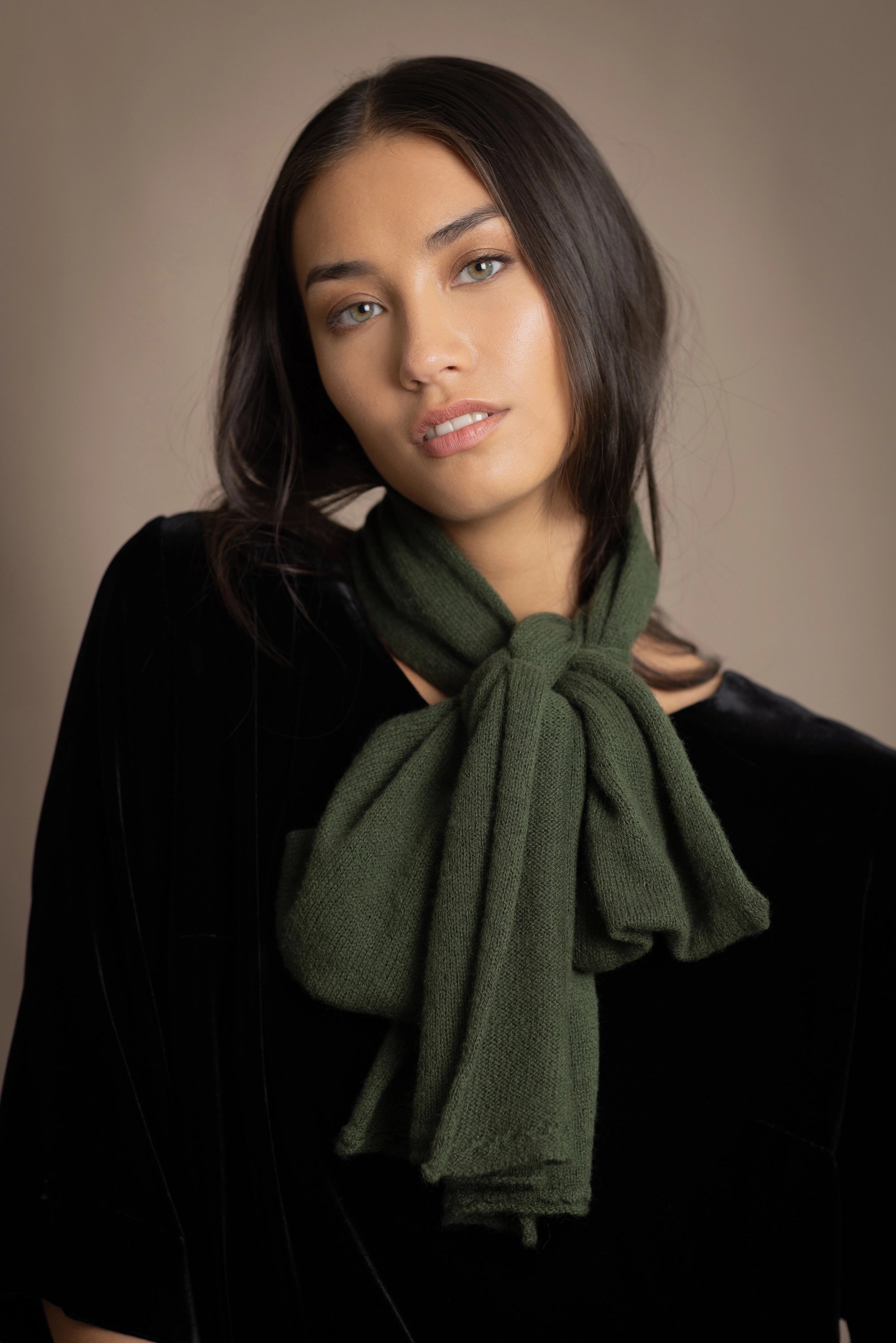 a woman wears a cashmere scarf in green