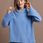 A woman wears a pure 100% cashmere hoodie sweater in blue