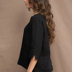 a woman wears an Irish linen top in black with matching black linen trousers by Irish brand Madigan 
