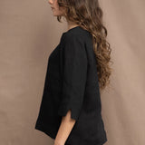 a woman wears an Irish linen top in black with matching black linen trousers by Irish brand Madigan 