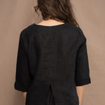 a woman wears an Irish linen top in black with matching black linen trousers by Irish brand Madigan 