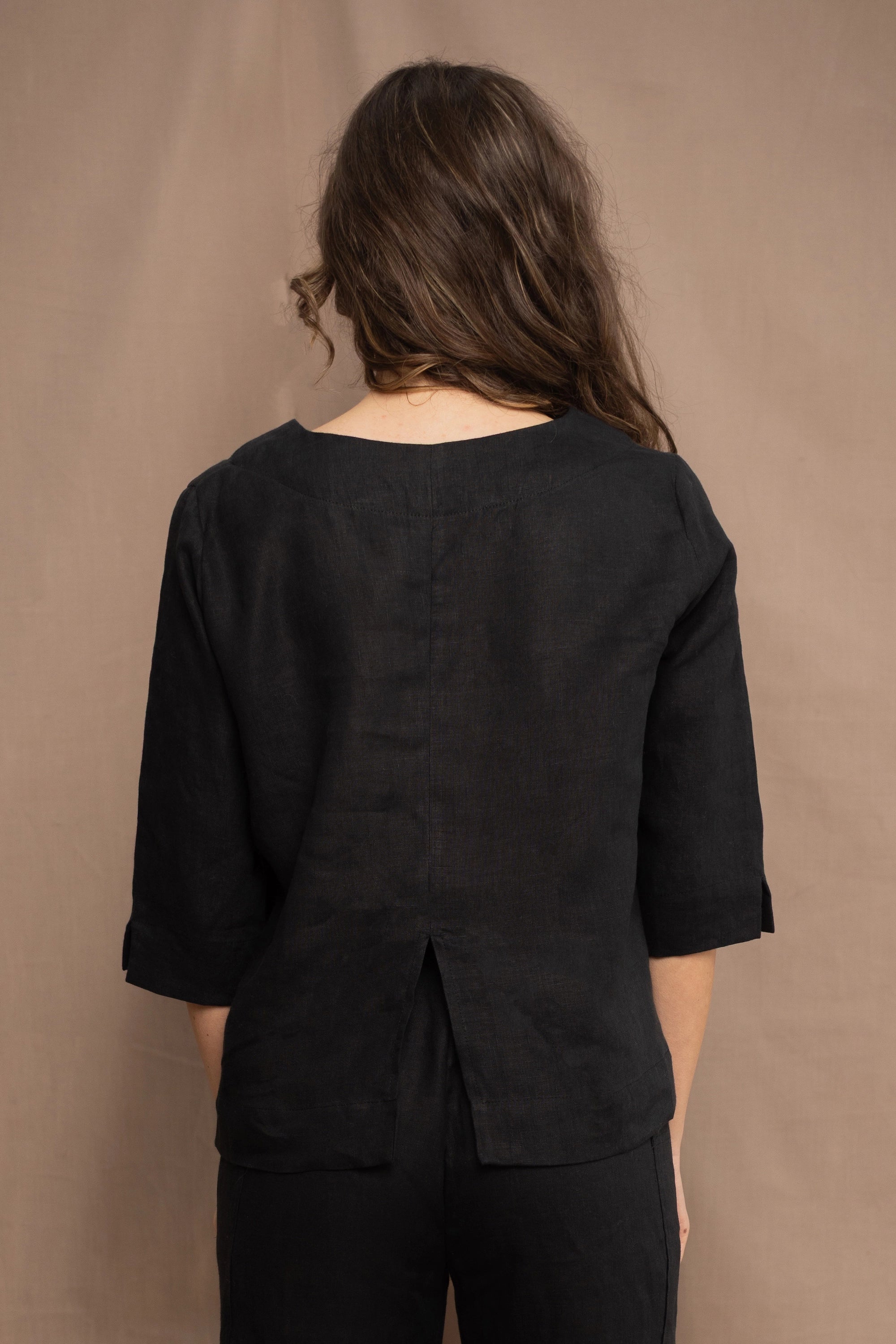 a woman wears an Irish linen top in black with matching black linen trousers by Irish brand Madigan 