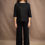 a woman wears an Irish linen top in black with matching black linen trousers by Irish brand Madigan 
