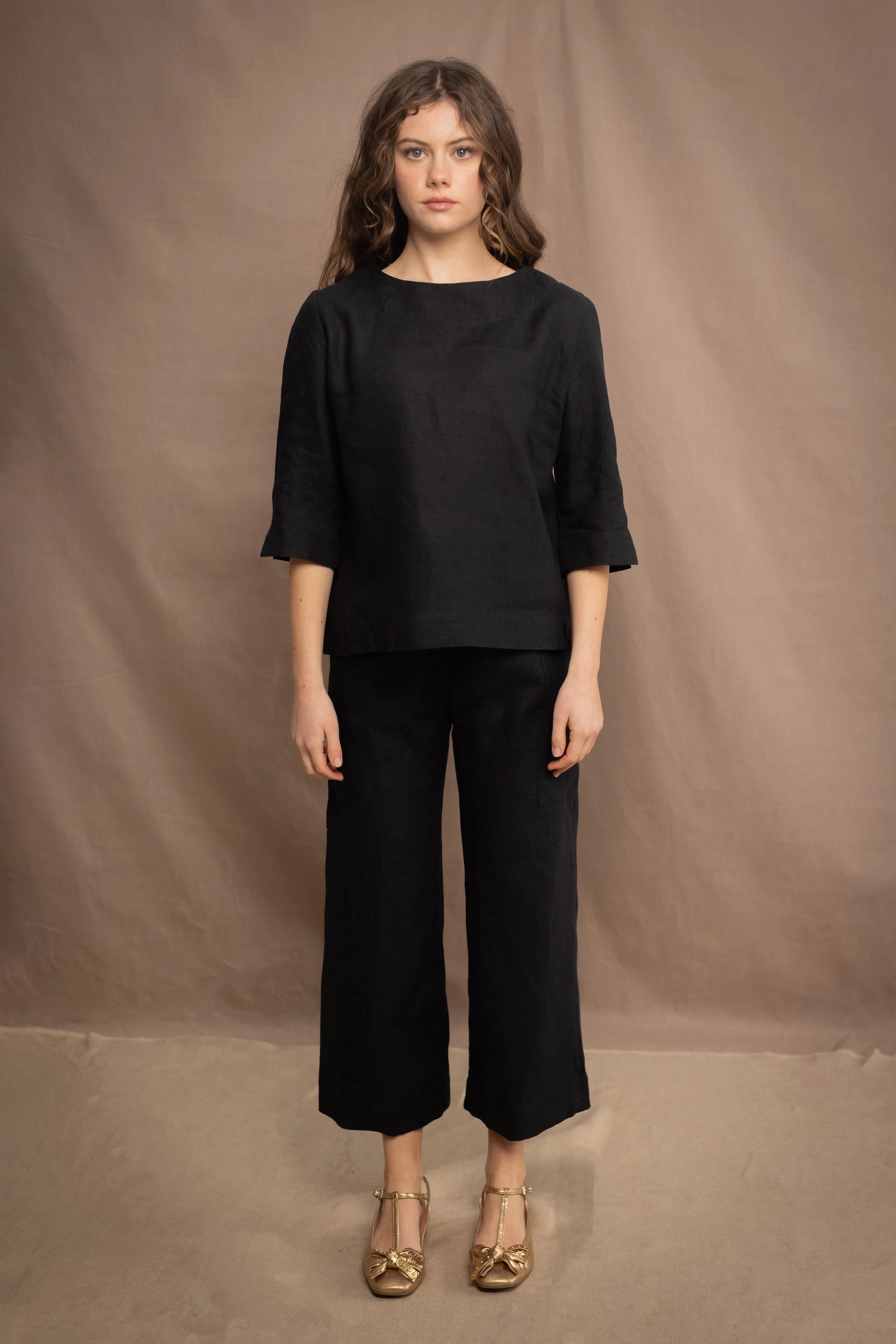 a woman wears an Irish linen top in black with matching black linen trousers by Irish brand Madigan 
