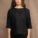 a woman wears an Irish linen top in black with matching black linen trousers by Irish brand Madigan 
