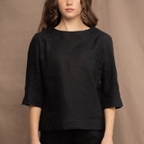 a woman wears an Irish linen top in black with matching black linen trousers by Irish brand Madigan 