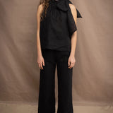 a woman wears a black wide leg Irish linen pants or trousers with matching halter neck top by Irish brand Madigan