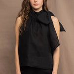 a woman wearing an Irish linen halter top with a bow detail around the neck in black with matching linen trousers by Irish brand Madigan