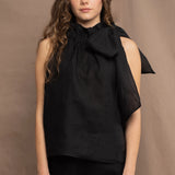 a woman wearing an Irish linen halter top with a bow detail around the neck in black with matching linen trousers by Irish brand Madigan