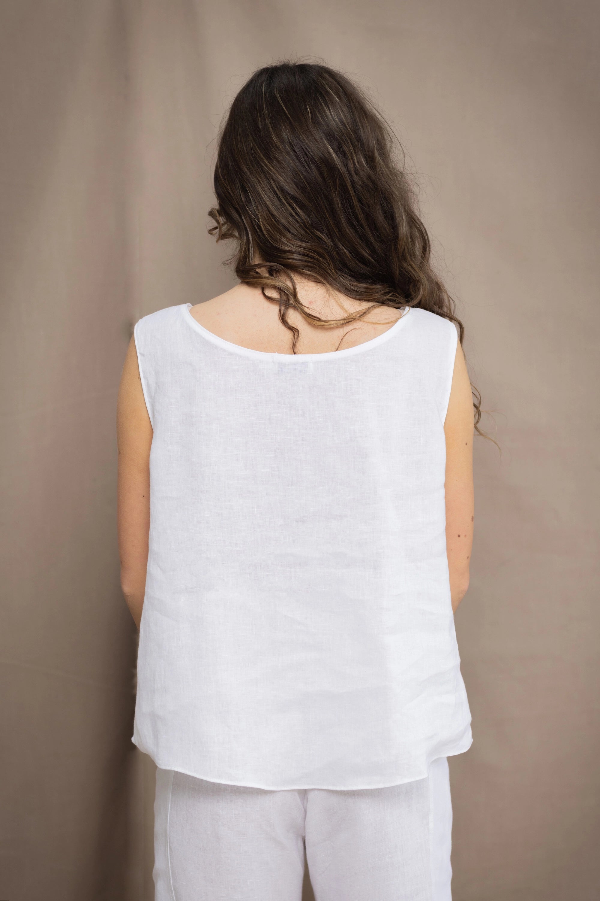 Woman wearing an Irish Linen sleeveless top and matching pants in white
